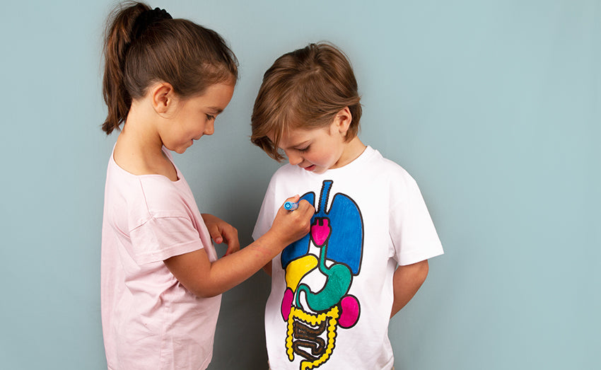 Child colouring the organs on a T shirt to learn basic anatomy- from Koa Koa
