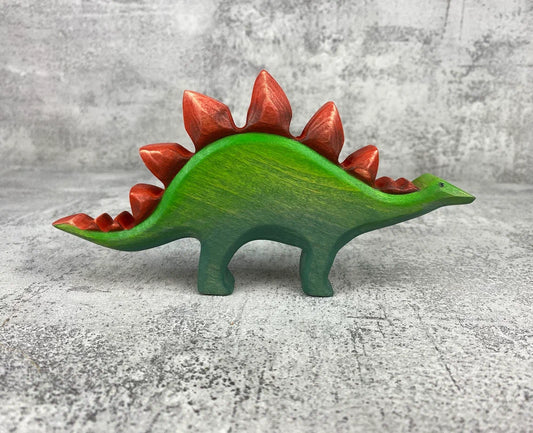 Wooden green stegosaurus dinosaur toy with red plates and spikes