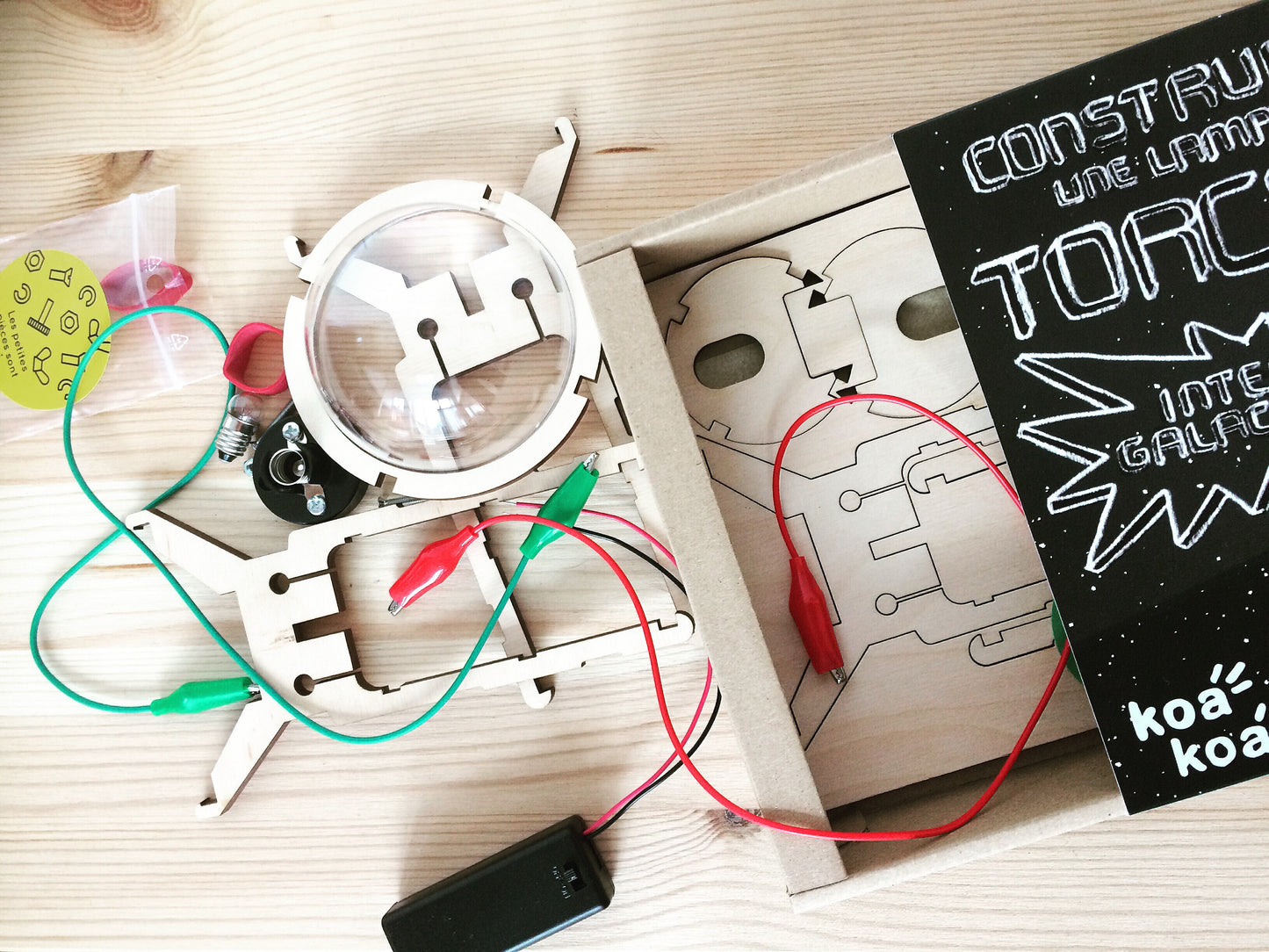 Components of Make your own flashlight kit for children: wires, torch components, bulb, battery.