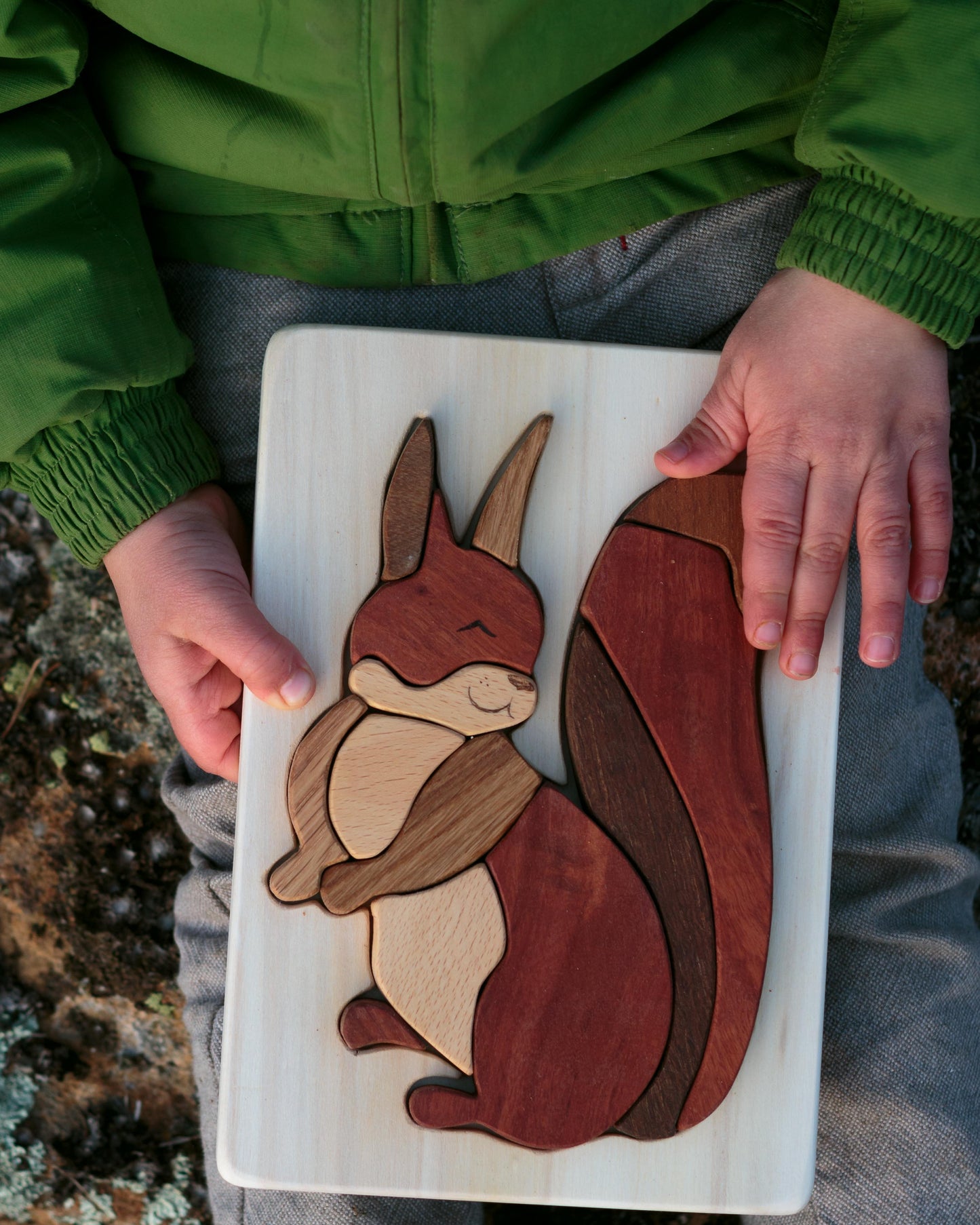 beautiful wooden toy puzzle squirrel from Cocoletes, on a child's lap