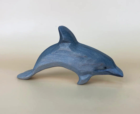 Grey hand-made wooden toy dolphin leaping out of the water