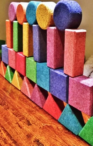 Cork building blocks in various colours, stacked into a wall 