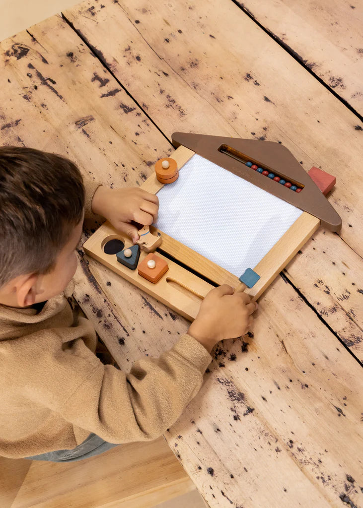 Child using magic drawing board, top view