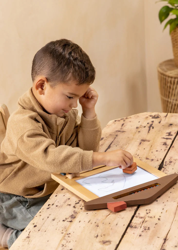 Boy using a stamp and chop on Oekaki magic drawing board