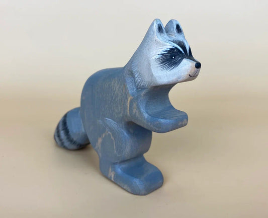 Wooden toy raccoon in grey with white head and bushy teail