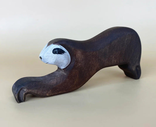 wooden sloth toy in brown, with extended paws