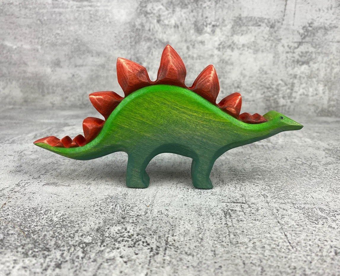 Wooden green stegosaurus dinosaur toy with red plates and spikes