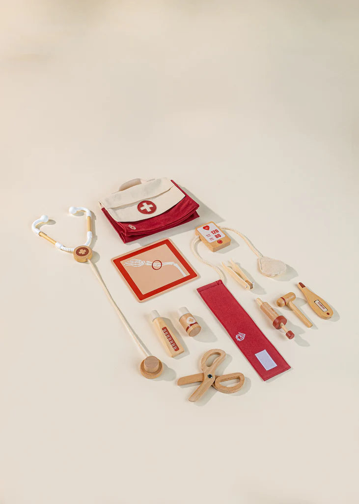 Components of wooden doctor playset with bag stethoscope, scissors, syringe, tendon hammer, pressure cuffs