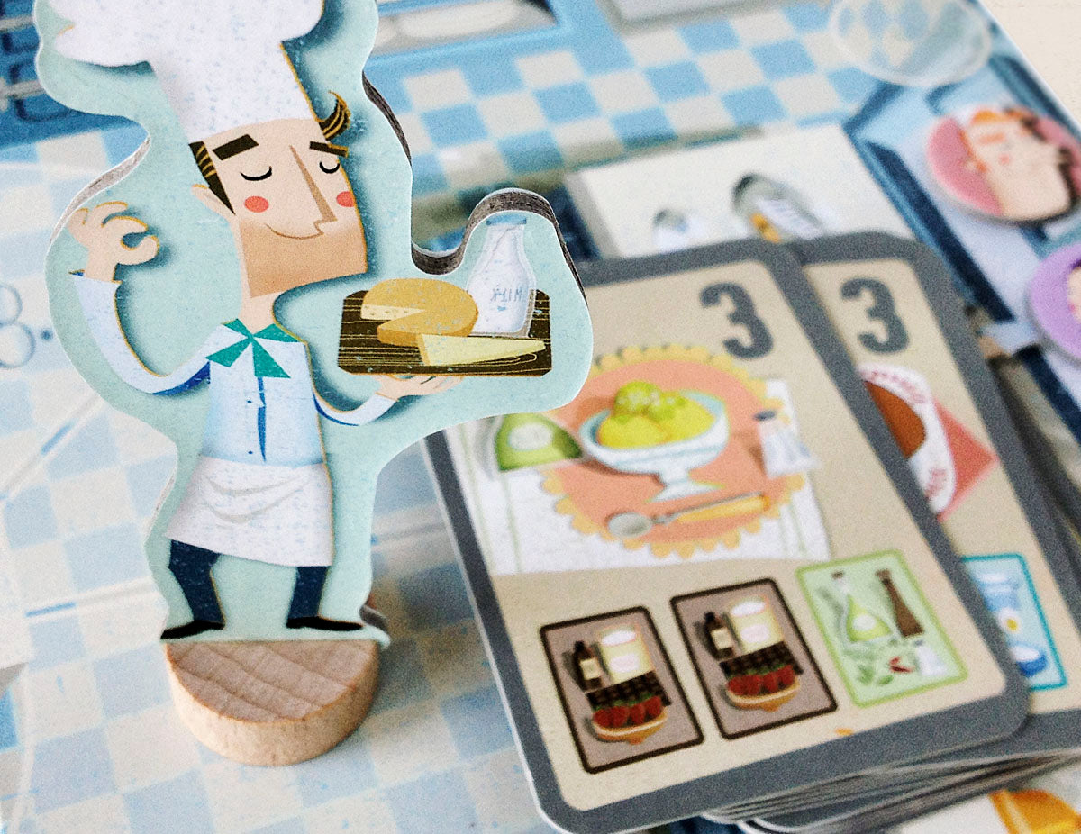 Up close photo of a chef in the board game carrying cheese and milk on a tray