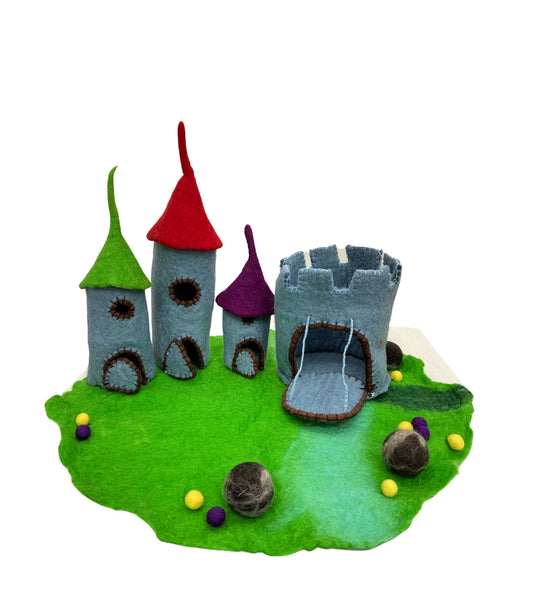Felted toy dragon castle with a green lawn, a castle with coloured roofs