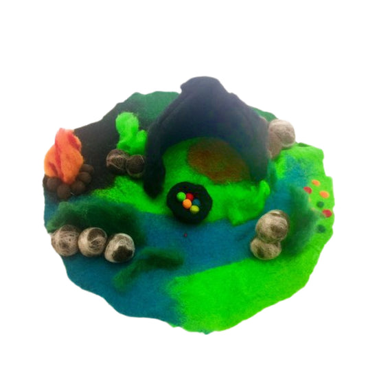 felted toy- dragon cave play mat with a stream, dark cave and a camp fire by the side